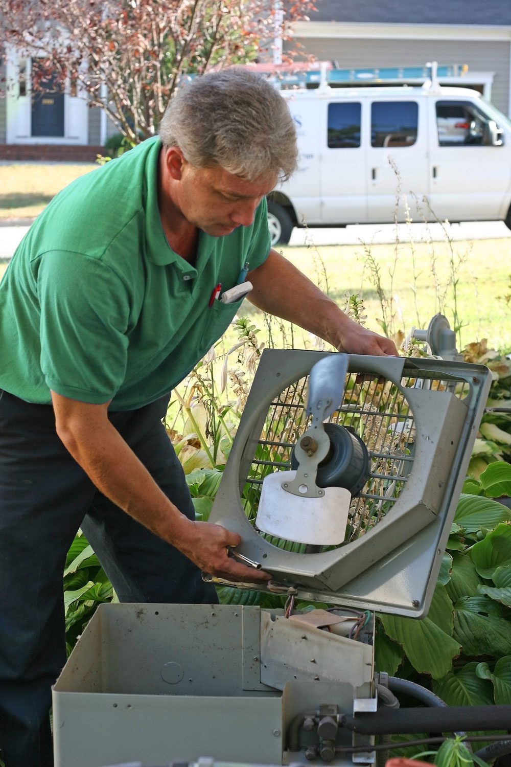 green-shirt-GettyImages-157282956 Palmetto Comfort Inc. | York County | technician repairing ac unit
